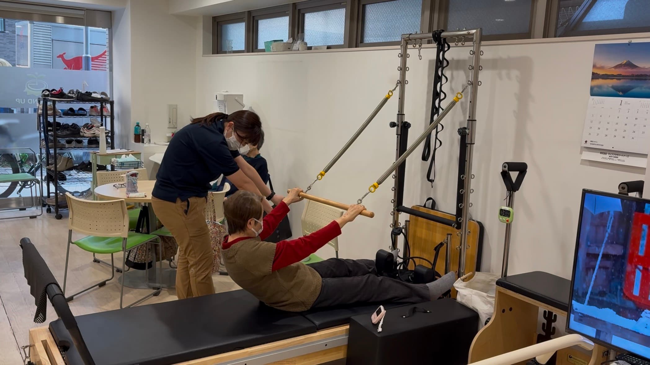 ピラティスマシンを使った運動療法をスタッフがサポートしている様子